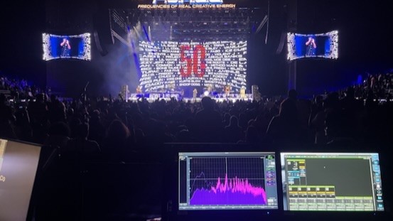 Stage with a large lit video wall, and a spectrum analyzer on the screen at the mix position