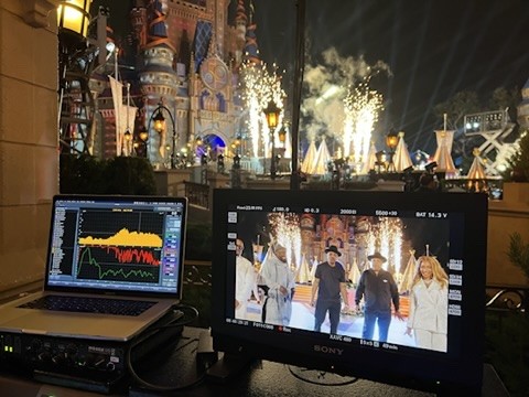 Laptop showing an audio analyzer beside a video monitor with a castle behind them