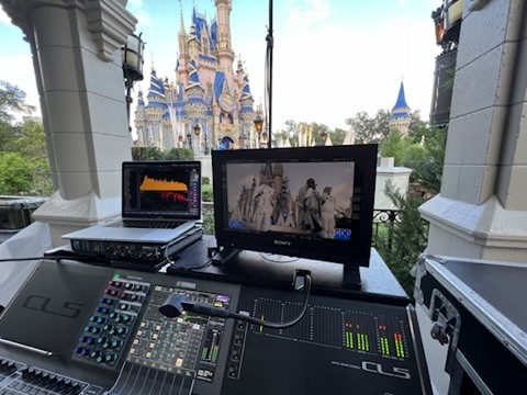 Console, laptop and video monitor on a balcony with a castle in daylight