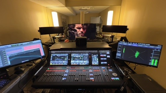 Mix room with a large console, a video monitor, meters and a computer screen