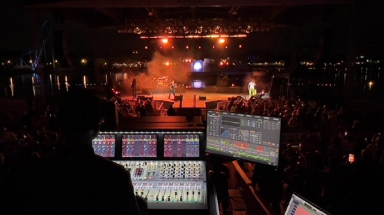 Console and a measurement screen at the mix position facing a waterfront stage